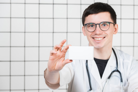 Smiling pharmacist holding a box of pills in the pharmacyの写真素材