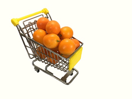 Closeup of shopping cart full of oranges on white background.の写真素材