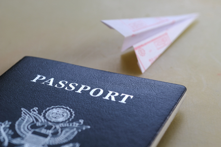 Passport on the table and folded from paper airplane with stamp of entry into the countryの写真素材