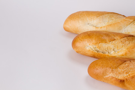 Three crusty French baguettes  isolated on white.