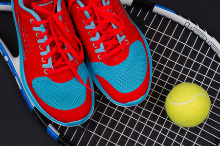 Bright women's running shoes with a tennis ball on a tennis racket. Bright set of sport.