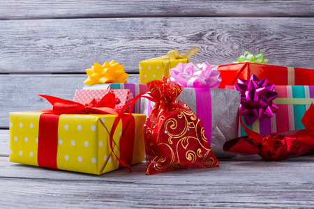 Gifts are packed in colored paper. Colored ribbons. Gift wrapping. Pile of Christmas gifts on a...