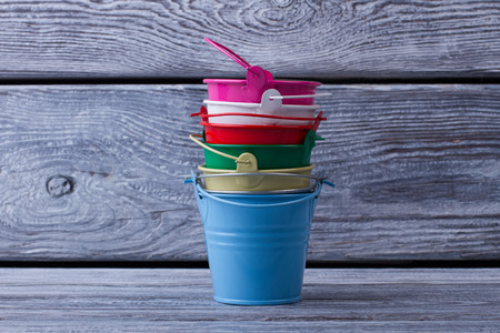 Stack of multi-colored buckets on the retro wooden background. Objects for the interior.の写真素材