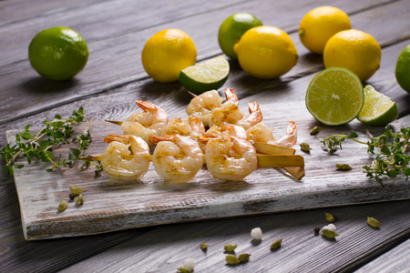 Shrimps grilled with lime and lemon on wooden board.の写真素材