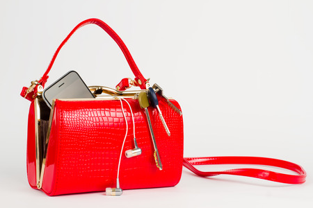 Beautiful lacquered red bag with keys and phone.の写真素材