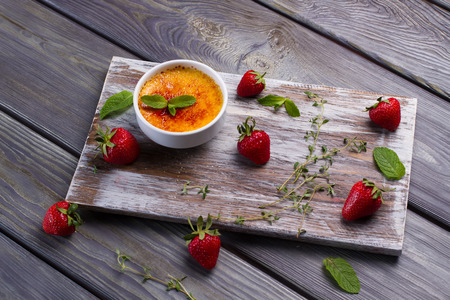 Appetizing cream brulee with strawberries and mint. Beautiful design of dessert. Italian dessert.の写真素材