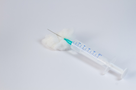 Plastic syringe with wadding on white background.の写真素材
