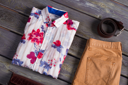 Beautiful shirt with accessories on a wooden background.の写真素材