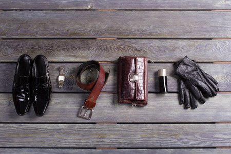 Brand men's accessories and shoes on a wooden background.の写真素材