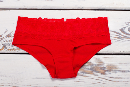 Red cotton underwear on a wooden background. Red pants with lace on every day.の写真素材