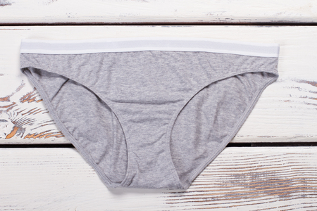 Classic everyday underwear. Gray comfortable cotton pants. Panties on a wooden background.の写真素材
