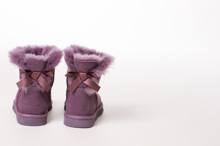 Australian Trendy winter shoes. Fur women's boots with ribbons on a white background.