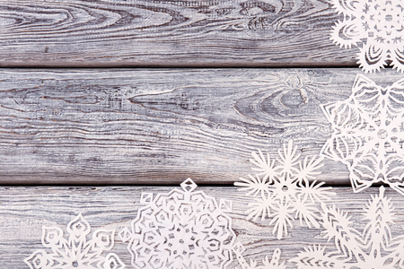 White snowflakes of different shapes on a gray wooden background. Christmas card. New Year soon.の写真素材