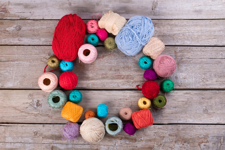 Colored yarn on a vintage wooden background. Skeins of wool yarn for knitting. Space for text. の写真素材