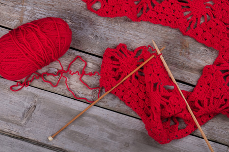 Red knitting and wooden knitting needles. Knitted background with knitting needle and ball of yarn.の写真素材