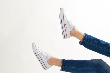 Female feet in gumshoes on a white background.の写真素材