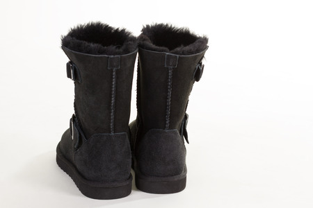 Backs of black suede winter boots. Natural sheep fur boots. Women's winter shoes.