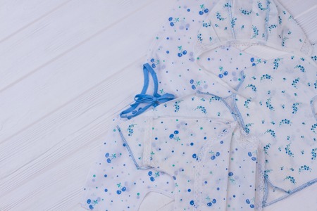 Infants outfit kids clothes. Collection of toddlers outwears. White wood background.
