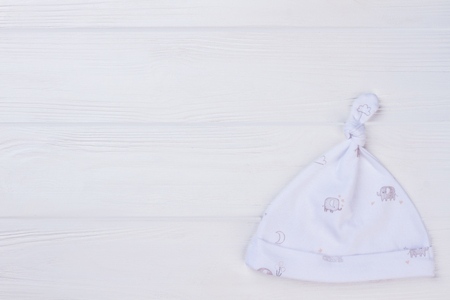 Organic Classic Knotted Baby Hat. White wood and copyspace.の写真素材