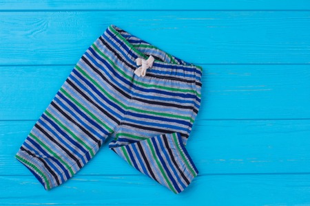 Toddler striped boxer shirts. Blue wood background.
