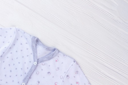 Babywear shirt and copyspace. White wood background.の写真素材