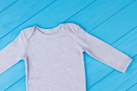 White cotton clothes for baby. Blue wood background.の写真素材