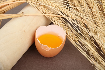 egg, rolling pin and ear of wheatの写真素材