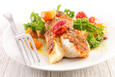 fish fillet with baked tomatoの写真素材