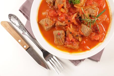 beef stew with tomato sauce and herbs on white backgroundの写真素材
