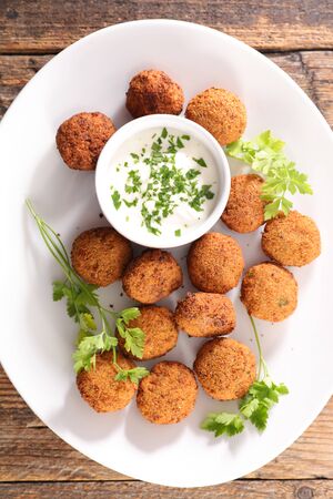 falafel with dipping sauce and herbの写真素材