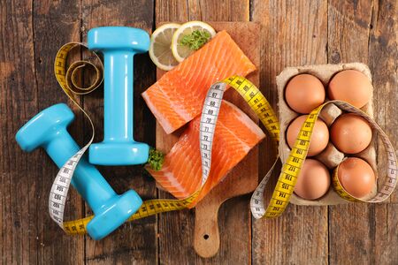 healthy food concept with meter, dumbbell and salmonの写真素材