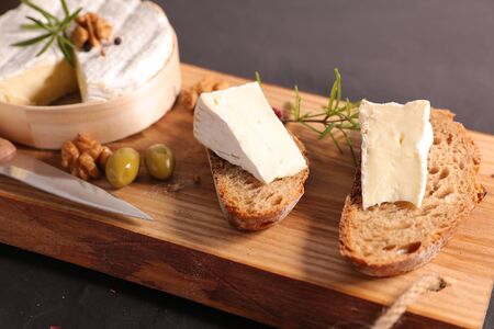 bread slice with camembert on wooden board