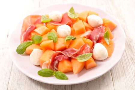 melon salad with mozzarella, prosciutto ham and basilの写真素材