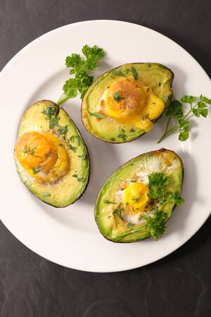baked avocado with egg and herbsの写真素材