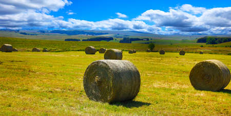 hay bale in a farm field with cloudy skyの写真素材