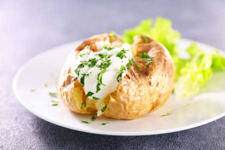 baked potato with cream and herbsの写真素材