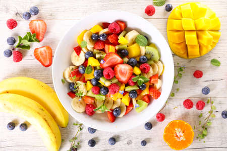 delicious fruit salad with banana, mango and berry fruitの写真素材