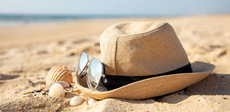 hat and sunglasses on the beachの写真素材