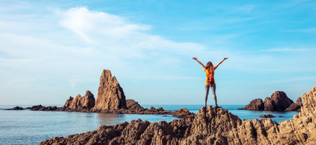 happy woman looking at rock formation in sea- Cabo de gata, Spain
