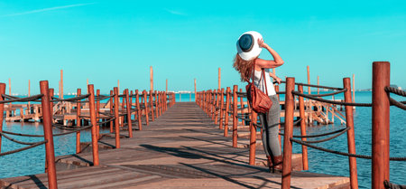 Woman on wooden pier looking at mediterranean seaの写真素材