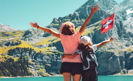 Mother and children holding swiss flag- Alps mountain and lakeの写真素材