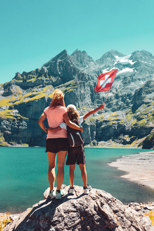 Mother and children holding swiss flag- Alps mountain and lakeの写真素材