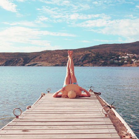 legs of woman on wooden pier- relax, happy, vacation conceptの写真素材