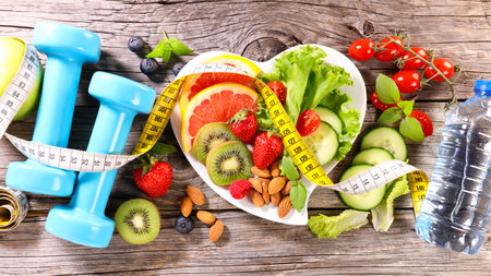 diet food concept- healthy eating- mixed salad, dumbbell and meter tape- fitness sport, active, slim conceptの写真素材