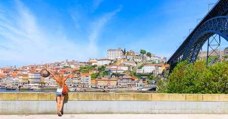 Panorama view of Porto cityscape, old town and dom luis bridge with woman traveler- Portugalの写真素材