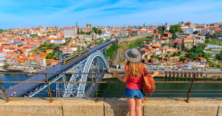 Woman tourist lookgin at panoramic cityscape of Porto- Portugal with famous Luiz Bridge and Douro riverのeditorial素材