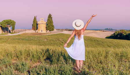 woman wearing white dress enjoying Tuscan landscape- travel, tourism in Italyの写真素材
