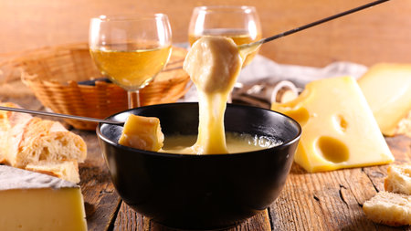 cheese fondue, bread and white wine glassesの写真素材