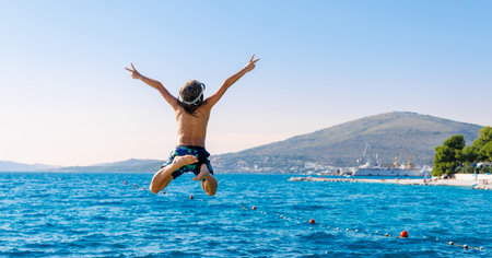 child jumping into sea in Croatiaの写真素材