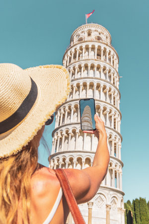 Woman tourist taking photography of Famous tower of Pisa in Italyの写真素材